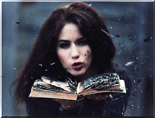 woman blowing on a book