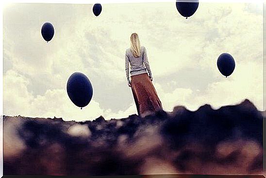 Woman with black balloons around