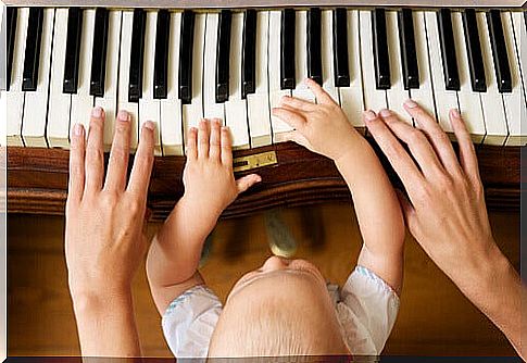 father playing piano with his baby