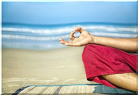 person meditating on the beach