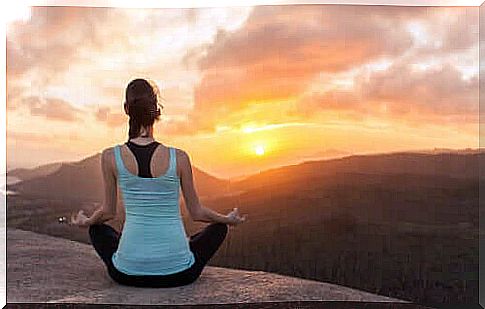 girl meditating on top of mountain