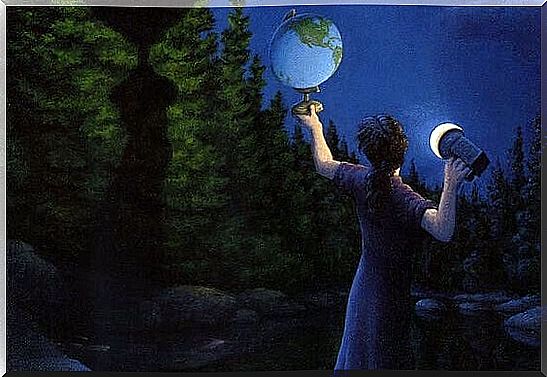 man looking at terrestrial globe with flashlight